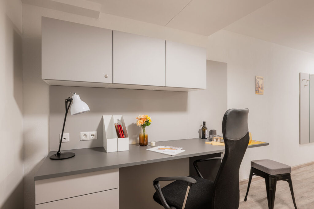 Zimmer mit Schreibtisch in Studentenheim
